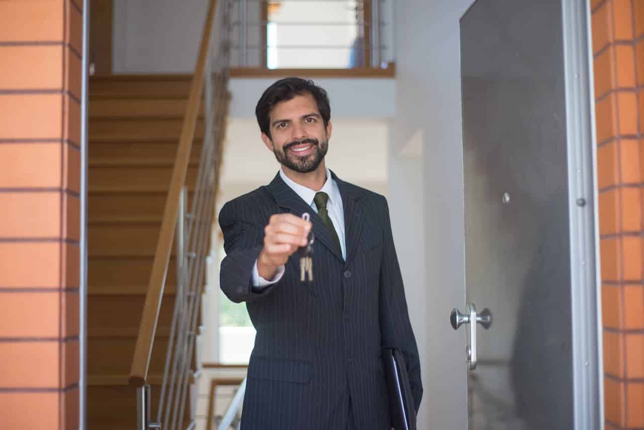 A professional real estate agent handing over keys to a new homeowner.