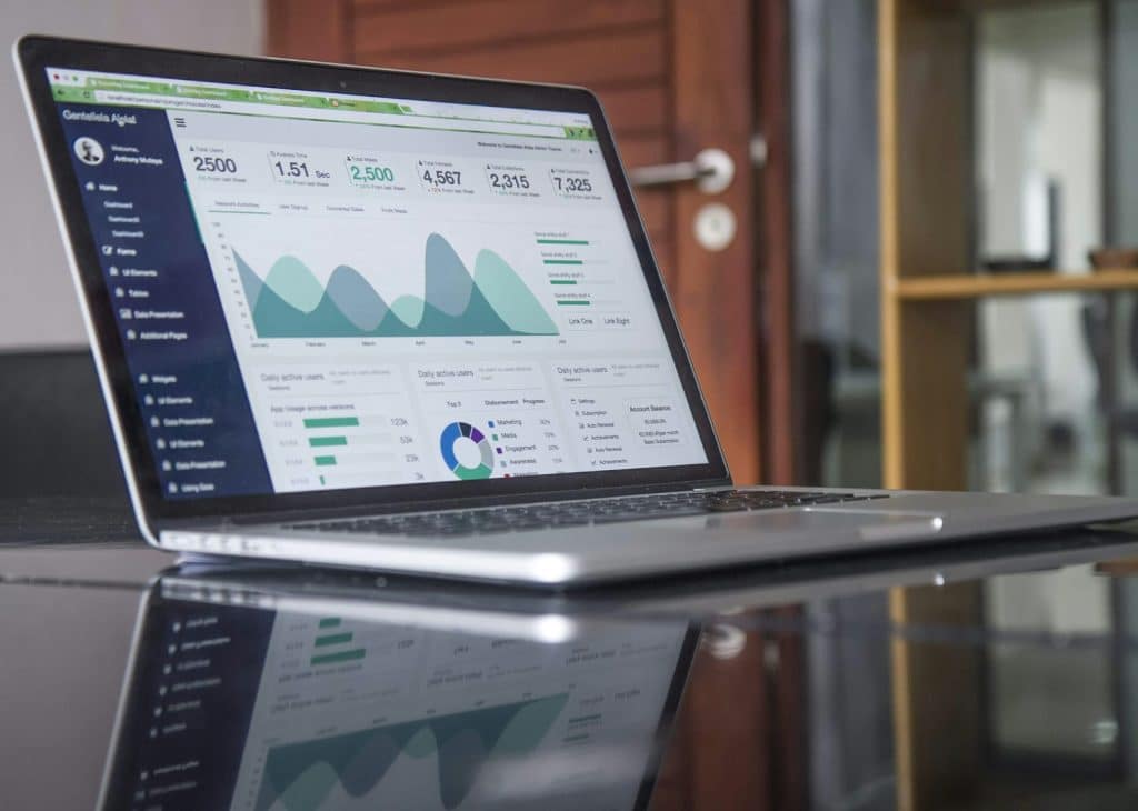 Laptop displaying a data analytics dashboard with graphs and statistics.